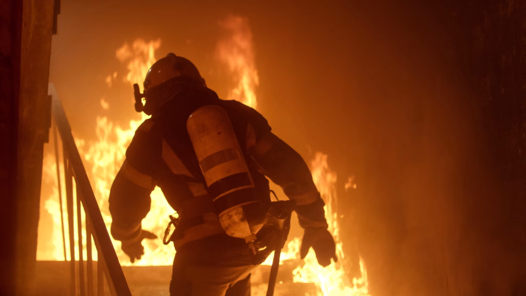Firefighter ascending stairs through flames
